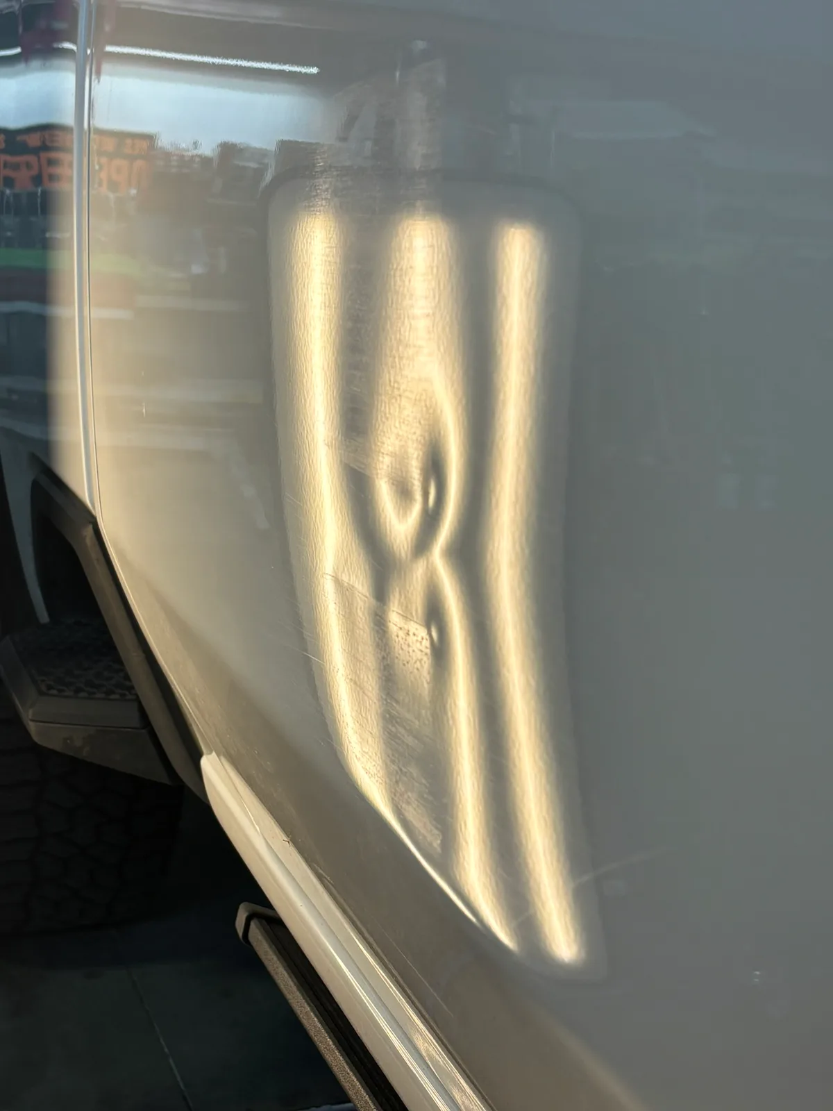 Truck side panel with a large hail dent made visible by LED lighting