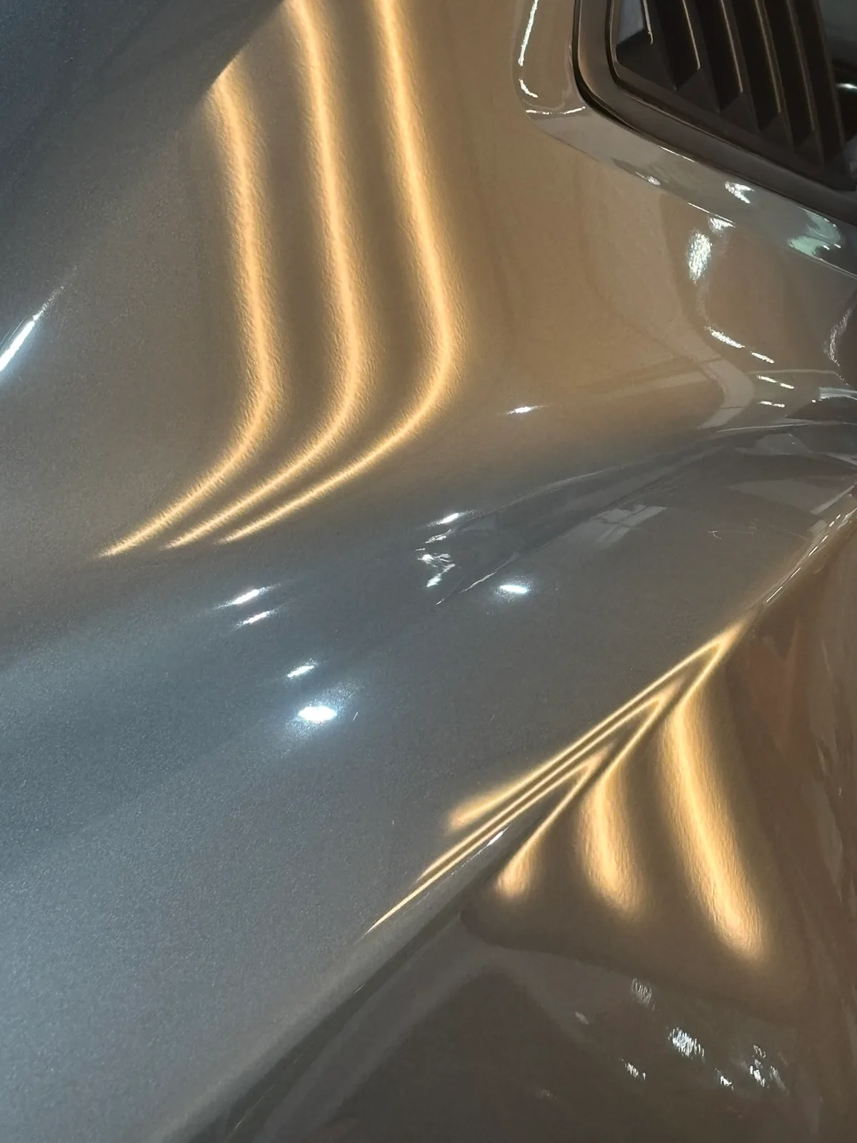 Quarter-size severe hail dents revealed under LED line-board inspection at the Olathe shop