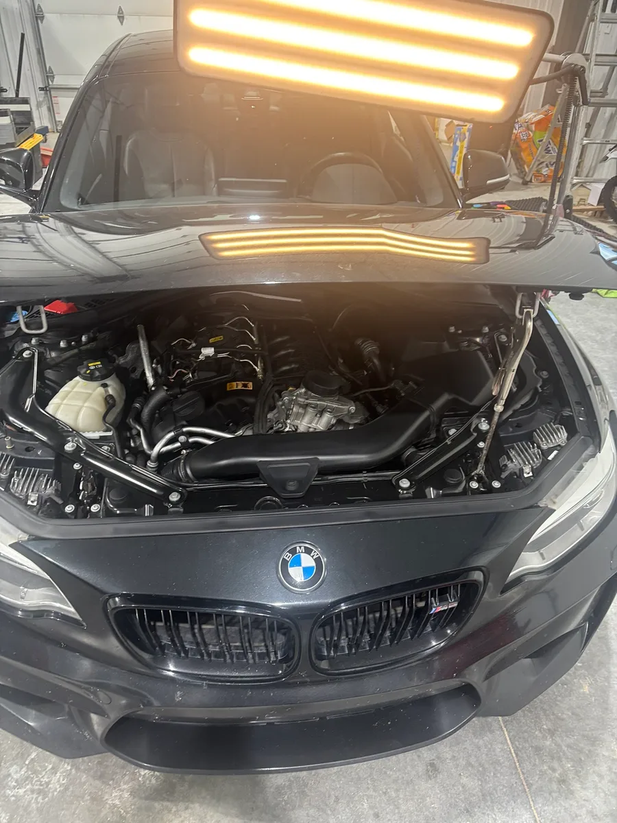 A hail-damaged BMW being restored with paintless dent repair at the Olathe shop